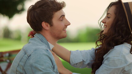 Handsome guy making laugh girl outdoors. Loving couple laughing on picnic