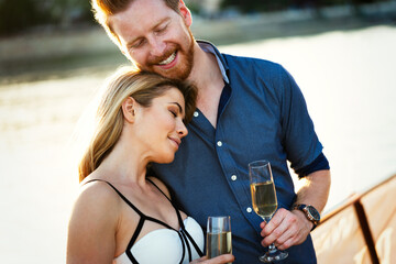 Poster - Happy young couple celebrating and drinking champagne a on a boat