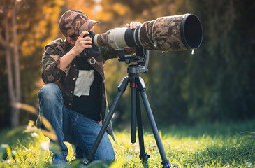 wildlife photographer using telephoto lens with camouflage coating photographing wild life using gim