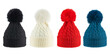 © KPad - Set of four woolen winter knitted hats of different colors with pompoms, isolated on a white background. Trends of this winter.