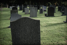 Blank Grave Stones Or Markers In A Cemetery With A Dark And Gloomy Filter Applied To The Image