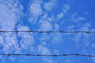 barbed wire against blue sky background