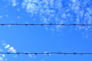 barbed wire against blue sky background