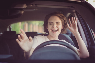 Sticker - Photo of positive cheerful girl funky driver rider enjoy drive ride car under pop star hits playlist music try dance raise hands in city center