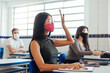 © kleberpicui - Brazilian college students wearing face masks sitting at the desk in the classroom. Concept of reopening of educational institutions in the COVID-19 pandemic