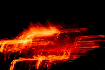 Fire sparks create imaginative yellow orange light trail pattern on black, creative effects for backgrounds