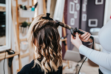 Wall Mural - Beautiful hairstyle of young woman after dyeing hair and making highlights in hair salon.