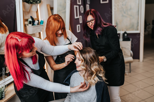 Beautiful hairstyle of young woman after dyeing hair and making highlights in hair salon.