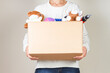 © vejaa - Woman hand holding donation box with clothes, toys and books