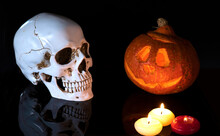 Halloween 2020 And Coronavirus. Happy Halloween Carving. Halloween Pumpkin Head Lantern On Black Background, With  Human Skull.  Idea For Halloween