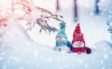 little snowmans on soft snow on blue background