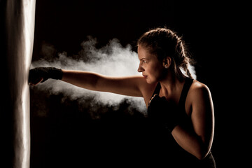 kick fighter girl punching a boxing bag