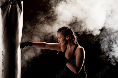фотографія kick fighter girl punching a boxing bag