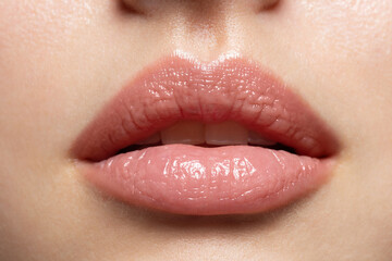 close up of young woman wearing light fresh lip make up and slightly opening mouth. plump lips with 