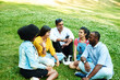 © etonastenka - Afghan, black, mexican and indian chatting while sitting in the park on the grass. The concept of communication of different nationalities