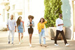 © etonastenka - College students walking together outdoors. Young beautiful people of different nationalities walk around the city and talk