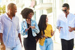 © etonastenka - Young beautiful people of different nationalities walk around the city and talk. Smiling Young Friends Walking Outdoors Together