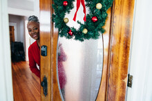 Senior Black Woman Opening Door For Visitors For Christmas Holiday