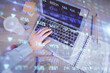 © peshkova - Double exposure of man's hands typing over computer keyboard and forex graph hologram drawing. Top view. Financial markets concept.
