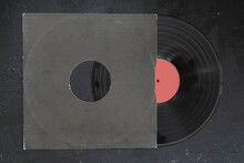 Aged Black Paper Cover And Vinyl LP Record Isolated On Black Background