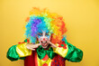 © Irene - Clown standing over yellow insolated yellow background shouting and screaming loud down with hands on mouth