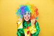 © Irene - Clown standing over yellow insolated yellow background very happy and excited making winner gesture with raised arms, smiling and screaming for success.