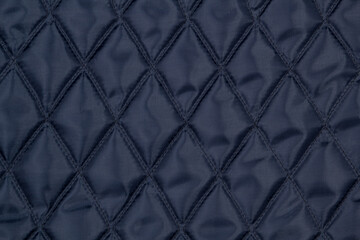  Blue quilted fabric. The texture of the blanket.	