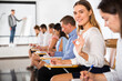 © JackF - Side view of young happy woman showing okay gesture while sitting in lecture hall during classes