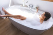 © Wavebreak Media - Woman holding coffee cup relaxing in a bathtub