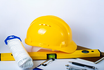 Safety First Concept: Safety Rope, notepad, level, metal wrenches and yellow helmet on the white table. Business and industry concept. Copy space for design.