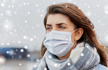 Wall Mural - health, safety and pandemic concept - young woman wearing protective medical mask outdoors in winter over snow