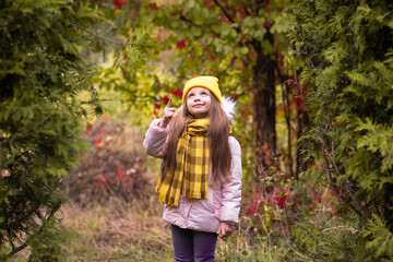 Wall Mural - A little girl walks in the autumn Park.