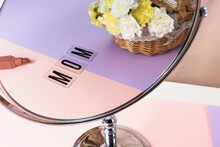 Mom Word With Bucket Of Flower Reflect In Mirror. Mother Day Concept.