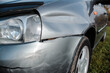 Damaged car after an accident. Impact dent on the car body, scratches and destruction.