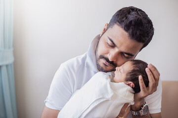 Closeup portrait of young asian Indian father holding his newborn baby with copy space. Healthcare and medical daycare nursery love lifestyle together single dad father’s day holiday concept