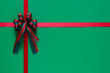 Christmas ribbon with bow on green background. Chrismas and New year concept.