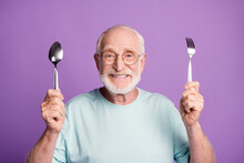Photo Of Positive Cheerful Old Man Hold Fork Spoon Ready Eat Wear Good Look T-shirt Isolated Over Violet Color Background