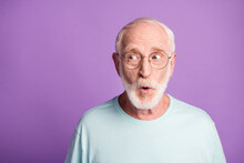 Portrait Of Surprised Pensioner Wear Light Blue T-shirt Glasses Open Mouth Empty Space Isolated On Violet Color Background