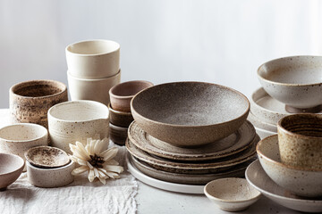 handmade ceramic tableware, empty craft ceramic plates, bowls and cups on light background 