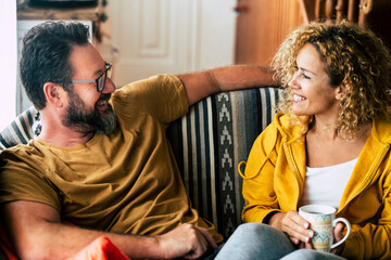 Happy young adult caucasian couple have breakfast together at home with smiles and happiness - concept of cheerful man and woman live together and have fun