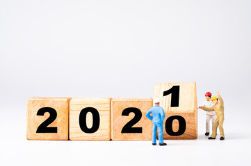 Wall Mural - miniature worker flipping wooden cubes block for change 2020 to 2021 , welcome new year concept.