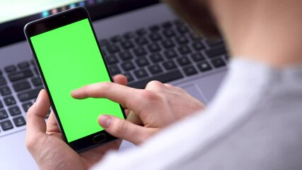 Poster - laptop background, of Internet commerce A black smartphone with green screen chroma key compositing swipe left the hands of a man on for and the use of online banking