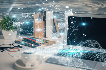 Desktop computer background in office and flying envelops hologram drawing. Double exposure. Electronic mail concept.
