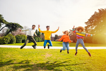 Group of for people friends jumping outdoor backlight - excitement, celebration, freedom concept