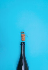 An open bottle of champagne on a blue background. The champagne cork.