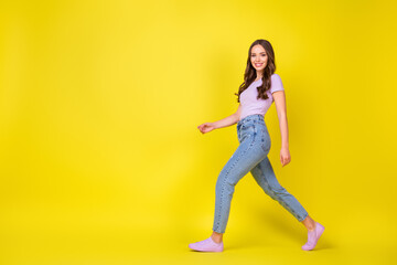 Sticker - Full length body size profile side view of lovely cheerful wavy-haired girl walking copy space isolated over bright yellow color background