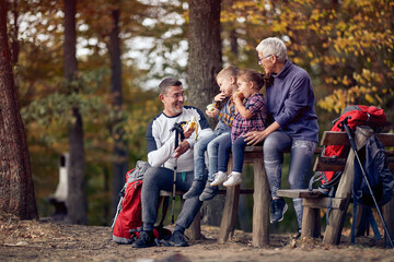 Poster - Grandmother, grandfather and grandchildren enjoying the fruits in the forest