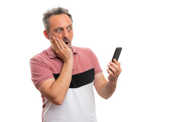 Man with shocked expression looking at smartphone screen