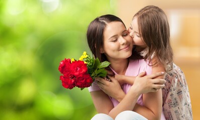 Canvas Print - Happy beautiful mother and daughter hugging with a bouquet