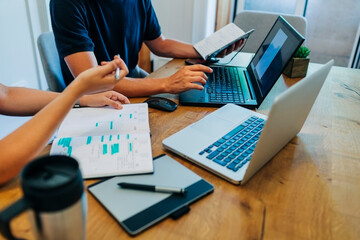 Computer programmers discussing over laptop at office desk